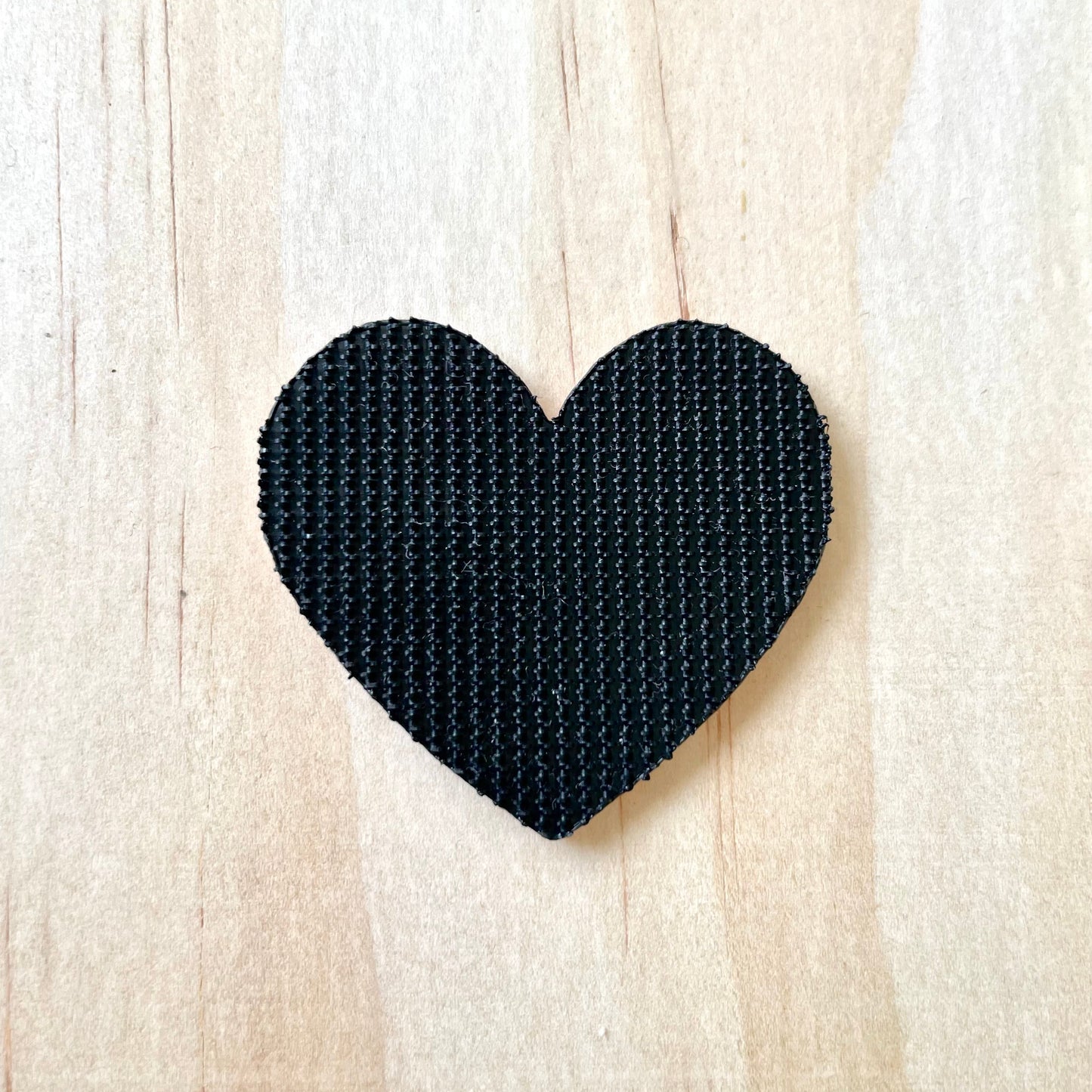 back side of a heart shaped velcro patch showing black short hook velcro