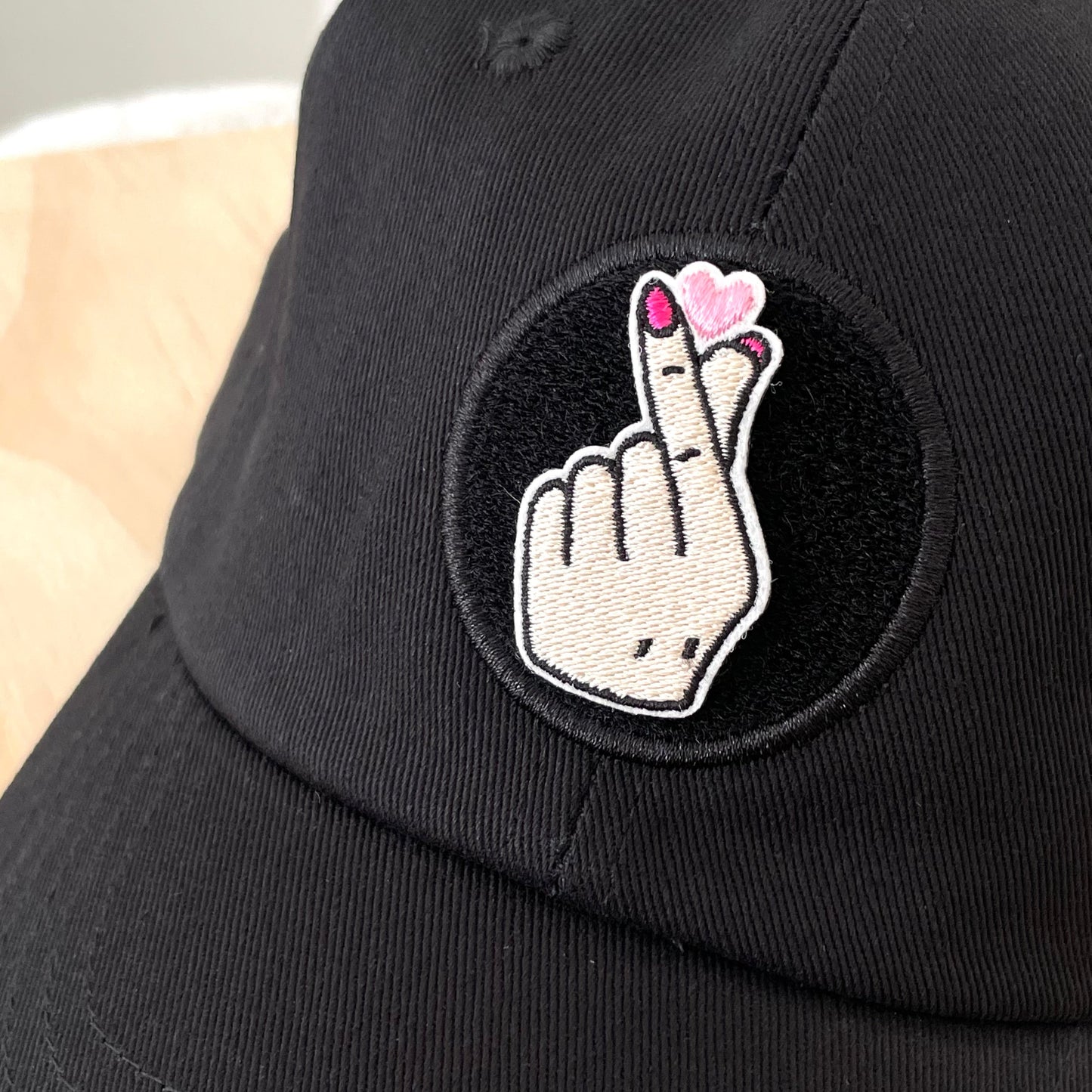Korean finger heart kpop heart velcro embroidered patch on black hat close up
